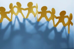 Figuras de papel en cadena simbolizando apoyo y bienestar en el trabajo