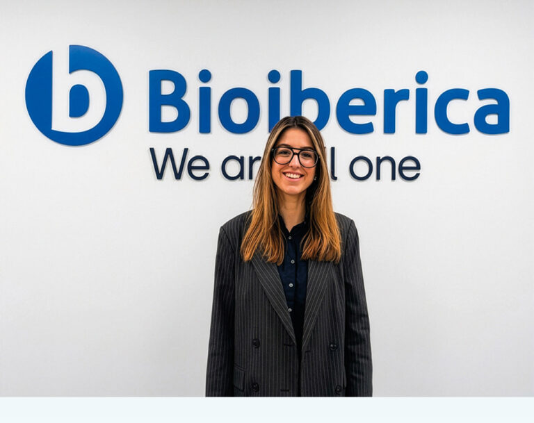Empleado de Bioibérica sonriendo frente a un logo en la oficina