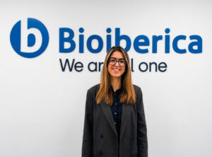 Empleado de Bioibérica sonriendo frente a un logo en la oficina