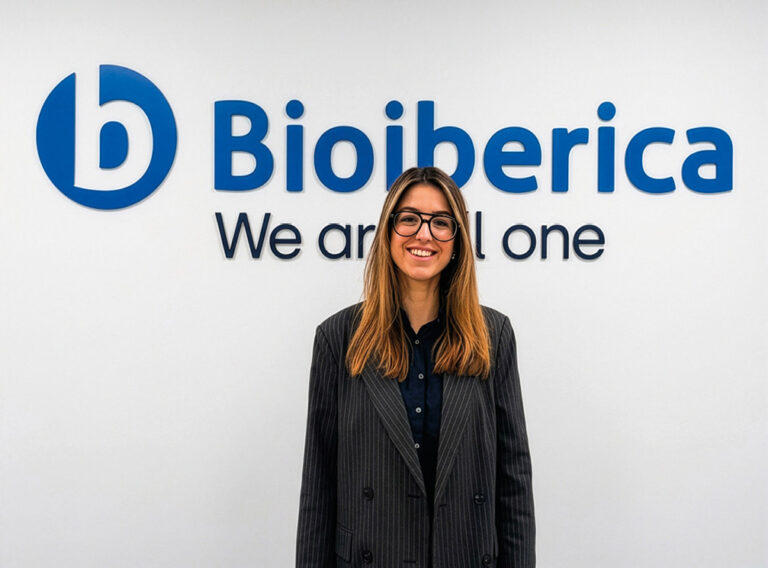 Empleado de Bioibérica sonriendo frente a un logo en la oficina