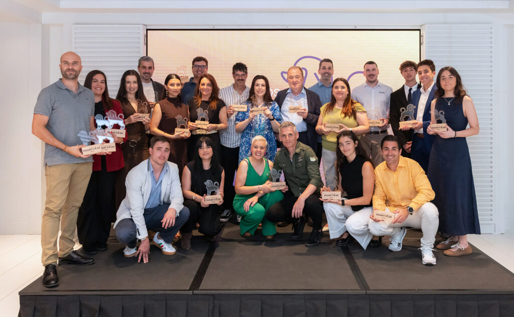 Grupo de personas posando con trofeos en un evento