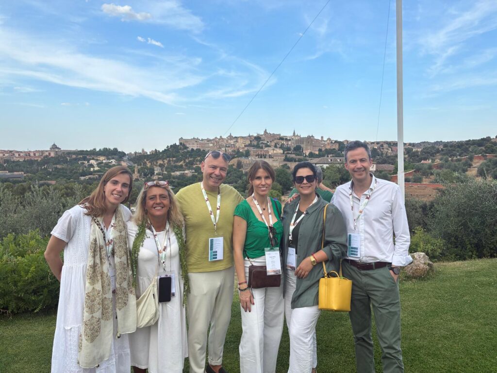 Grupo de personas posando con un paisaje de fondo en un evento